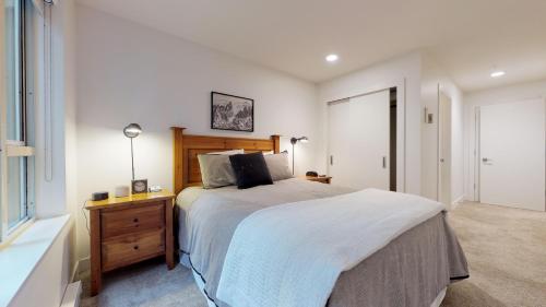a bedroom with a large bed with a wooden headboard at Bear Lodge, Whistler Village - Spectacular Location on Village Stroll, Designer Remodel in Whistler