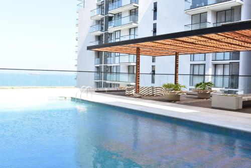 a swimming pool in front of a building at Lujoso apto con vista al mar, en salinas del mar in Playa Dormida