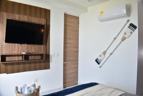a bedroom with a tv and a bed with a towel at Lujoso apto con vista al mar, en salinas del mar in Playa Dormida