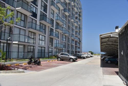 a building with cars parked in a parking lot at Lujoso apto con vista al mar, en salinas del mar in Playa Dormida