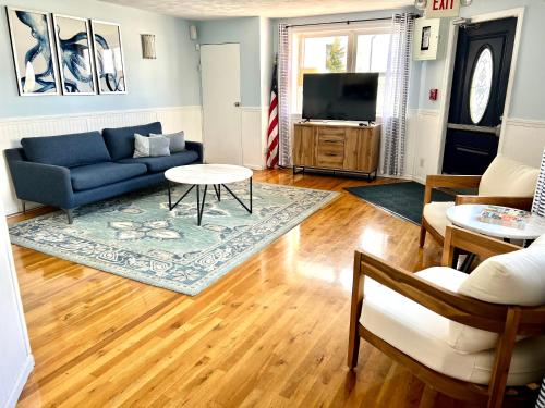 a living room with a blue couch and a tv at Harbor Landing Resort in Vineyard Haven