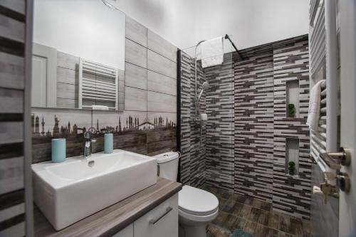 a bathroom with a white sink and a toilet at Garden Apartment Ultracentral in Oradea