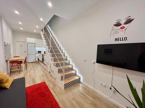 a living room with a spiral staircase with a tv at Oporto Blue Boavista - Deluxe City Center Duplex in Porto