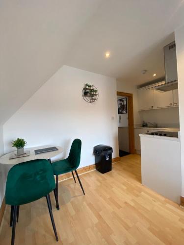 eine Küche mit einem Tisch und einem grünen Stuhl in einem Zimmer in der Unterkunft Spacious 1 bedroom apartment in Norwich city centre in Norwich