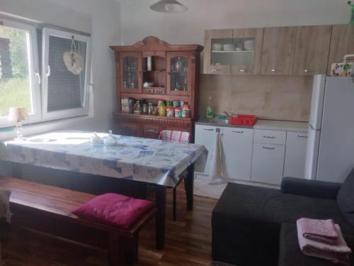 a kitchen with a table and a white refrigerator at Etno domaćinstvo in Bosanska Dubica