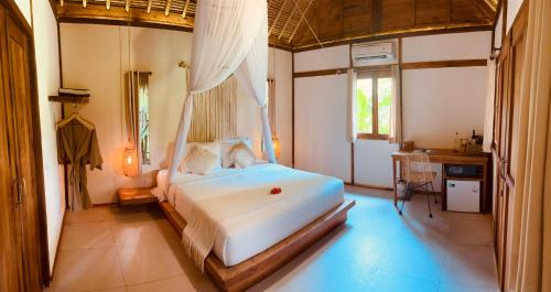 een slaapkamer met een wit bed in een kamer bij Green Escape Eco Resort in Uluwatu
