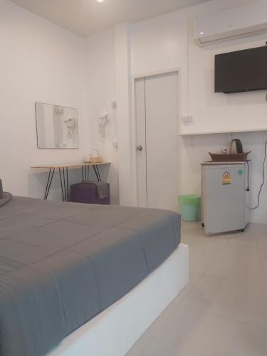 Habitación blanca con cama y TV en Seasmile kohlarn en Ko Larn