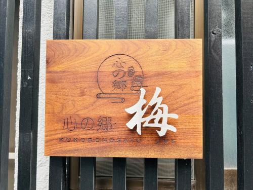 a sign on a fence with writing on it at Kokoro no sato・Ume in Kyoto