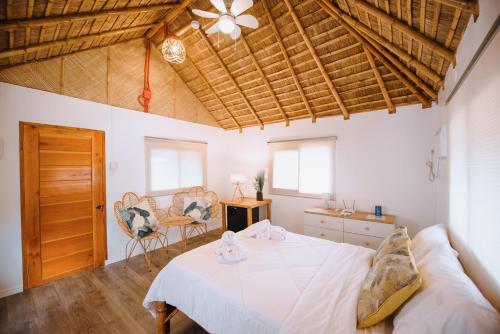a bedroom with a white bed and a wooden ceiling at Malabuyoc Resort Cebu in Cerdeña
