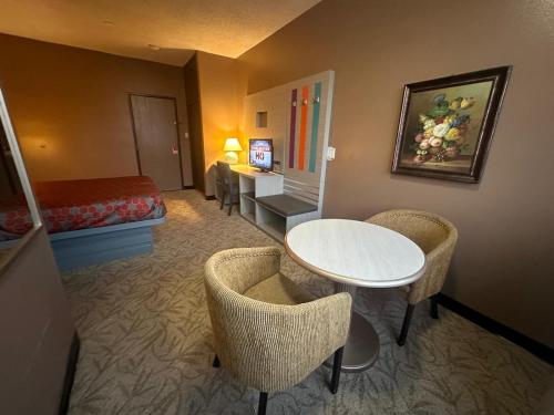a hotel room with a bed and a table and chairs at Hotel Pacific Garden in Gardena