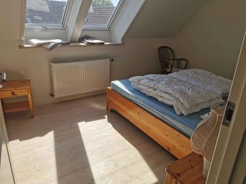 an attic bedroom with a bed and a window at Lovely Farmhouse For The Whole Family in Slagelse