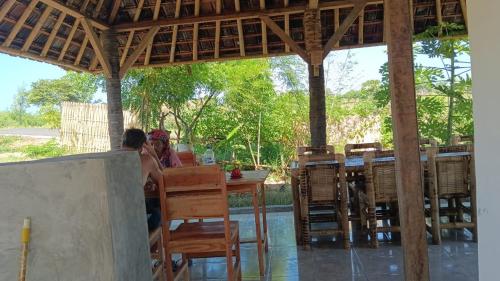 een stel aan een tafel in een restaurant bij Melody Surf Camp - Ekas Lombok in Ekas