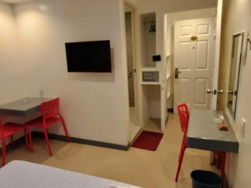 a living room with a table and a television on a wall at Hotel Sogo Avenida in Manila