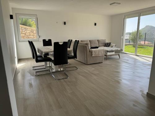 a living room with a couch and a table and chairs at Bela Bar in Dobra Voda