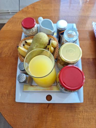 a tray with a glass of orange juice and some food at Mill House Apartment and Camping in Ljutomer