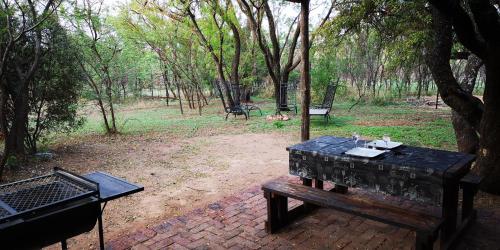 a picnic table and a grill in a park at Die Boshuisie in Rayton
