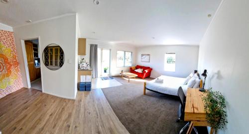 a living room with a bed and a couch at Peace and Aroha Mangawhai - Apartment in Mangawhai