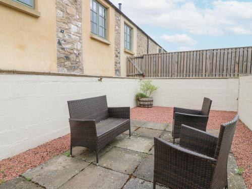 two chairs and a bench on a patio at Cartshed in Kelso