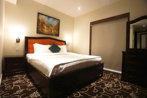 1 dormitorio con 1 cama grande y espejo en Naylover Hotel Suites, en Amán