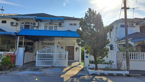 a white house with a gate in front of it at Good Old Days Butterworth Homestay near Raja Uda in Butterworth