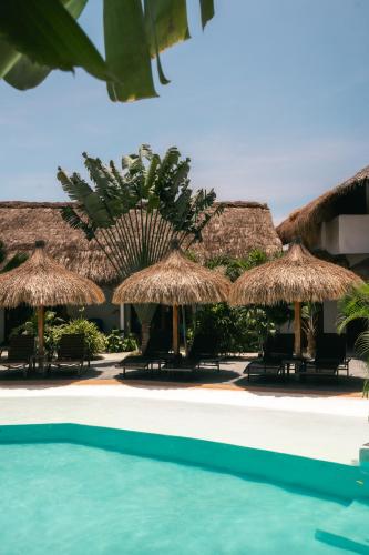 a resort with a swimming pool and straw umbrellas at Secret paradise moalboal in Moalboal