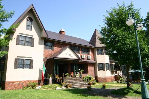 a building with a clock on the front of it at Pension Syo in Hakuba