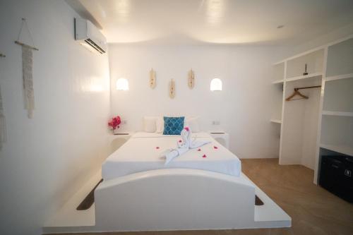 a white room with two beds in it at Secret paradise moalboal in Moalboal