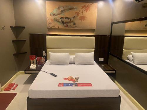 a bedroom with a large bed with white sheets at Hotel Sogo Malate in Manila