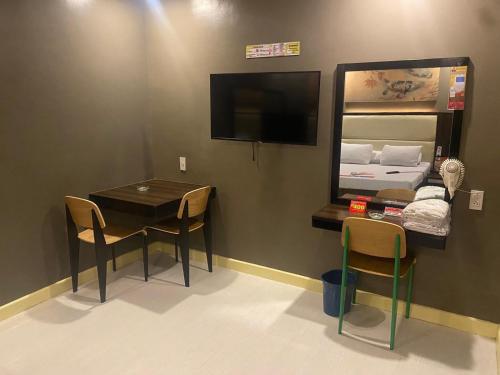 a small room with a table and a bed at Hotel Sogo Malate in Manila
