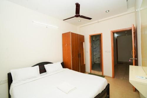 a bedroom with a bed and a ceiling fan at Golden Villa - Duplex House With Private Theater - Near To Alipiri And Bhudevi TTD Ticket Counter And Kapilateertham in Tirupati