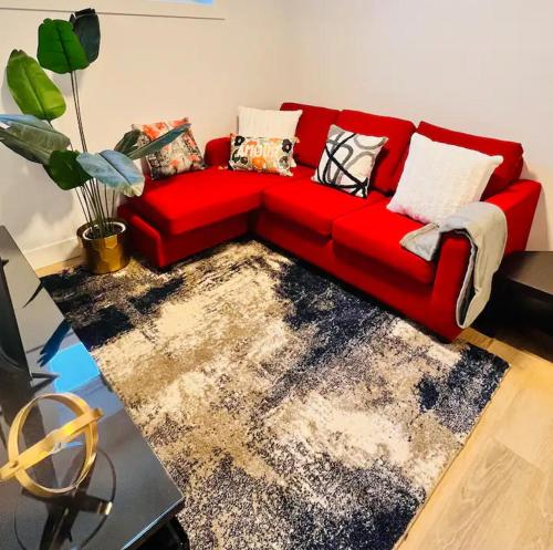 a red couch sitting in a living room at B21 River Valley 2bd Basement Suite in Edmonton