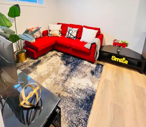 a red couch sitting in a living room at B21 River Valley 2bd Basement Suite in Edmonton
