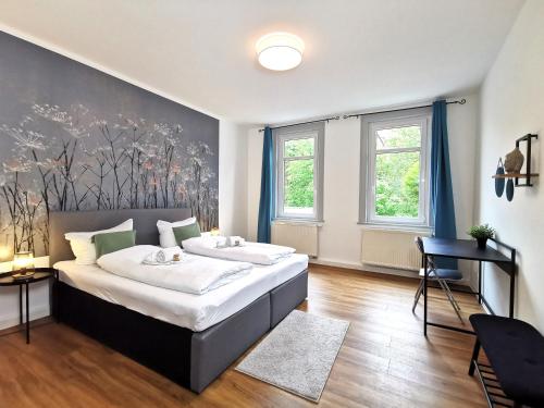 1 dormitorio con 1 cama grande y 2 ventanas en BohnApartments - Stadtblick Zechenhaus - Balkon - gratis Parkplatz - WLAN - sehr ruhig - barrierearm, en Ilmenau