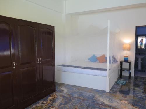 モアルボアルにあるThe Wild Orchid Resort - Moalboalのベッドルーム1室(ガラス張りのベッド1台付)