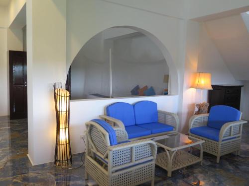 a room with two chairs and a table and a mirror at The Wild Orchid Resort - Moalboal in Moalboal