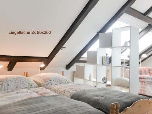 a attic bedroom with two beds and a window at Ap Kiebitz - Haus Nordlichter in Wendtorf