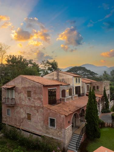 an exterior view of a stone house with a bridge at La Toscana in Suan Phung
