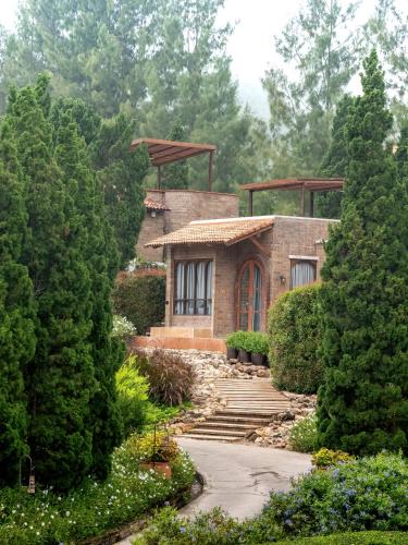 a house in the middle of a garden at La Toscana in Suan Phung