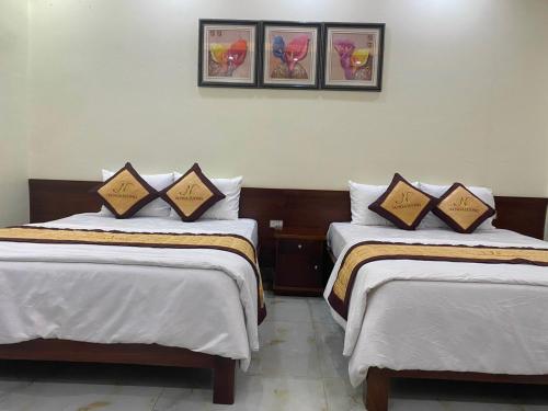 2 łóżka w pokoju hotelowym z białą pościelą w obiekcie Nhà hàng 34 Nga Lượng Cao Bằng w mieście Cao Bằng