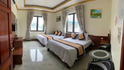 2 łóżka w pokoju hotelowym z oknami w obiekcie Nhà hàng 34 Nga Lượng Cao Bằng w mieście Cao Bằng