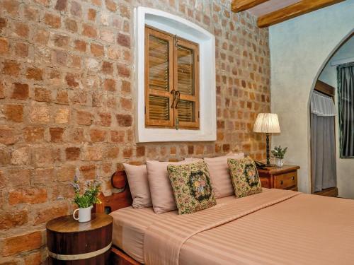 a bedroom with a bed and a brick wall at La Toscana in Suan Phung