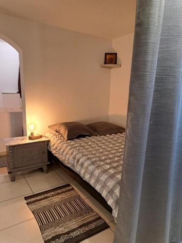 - une chambre avec un lit doté d'un rideau bleu dans l'établissement Studio sur les hauteurs de La Ciotat vue mer, à La Ciotat