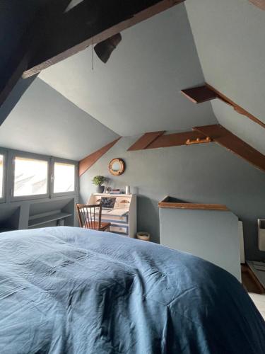 - une chambre mansardée avec un lit et un bureau dans l'établissement Confiserie de la Fontaine, à Saint-Quay-Portrieux