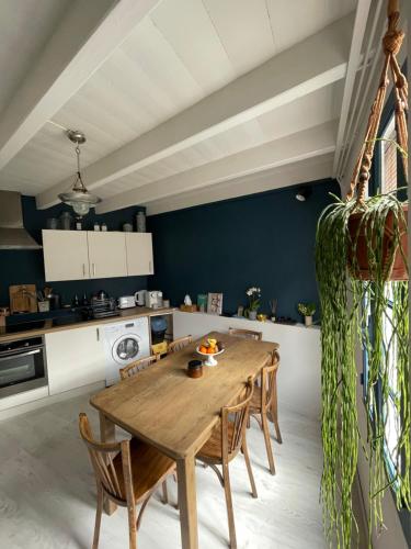 une cuisine avec une table et des chaises en bois dans l'établissement Confiserie de la Fontaine, à Saint-Quay-Portrieux