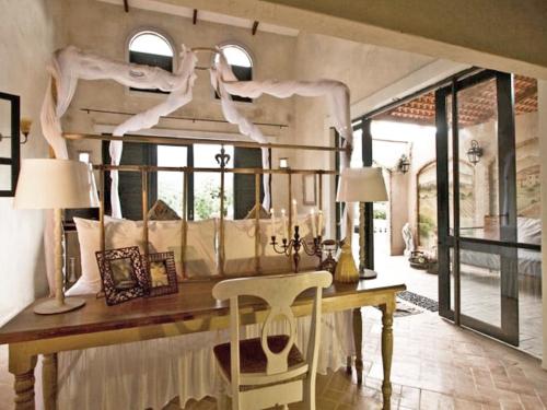 a dining room with a table and chairs and windows at La Toscana in Suan Phung