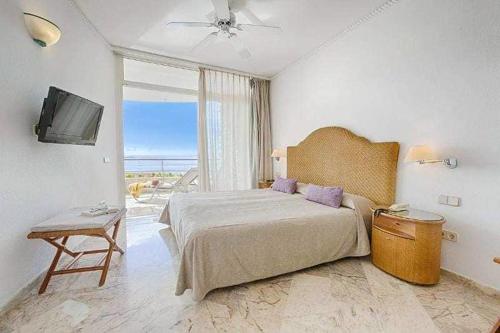 1 dormitorio con 1 cama grande y TV en Puerto Anfi- Luxury- Penthouse- Sleeps 9- Amazing Sea Views en Mogán