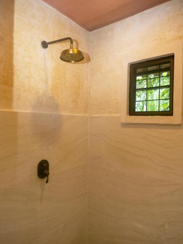 a bathroom with a shower with a window at La Toscana in Suan Phung