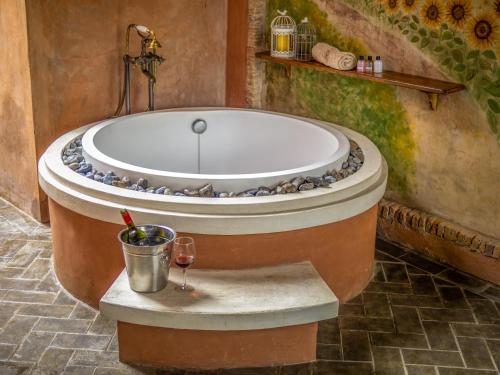 a bath tub in a bathroom with a glass of wine at La Toscana in Suan Phung
