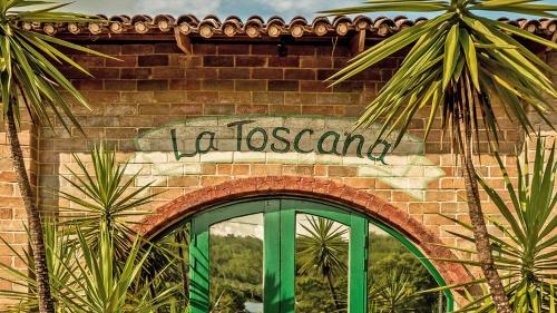 a brick wall with a sign that reads la toscana at La Toscana in Suan Phung