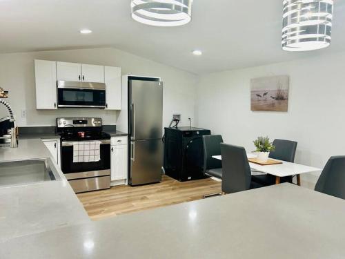 een keuken met een roestvrijstalen koelkast en een tafel bij Serene Mfd Home near Lake Norman in Denver